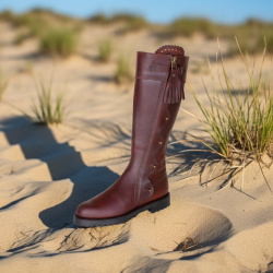 Spanischer Reitstiefel Pico braun, mit verziert verdecktem Aussenreissverschluss und Bommel am Zipper, Seitansicht, im Sand