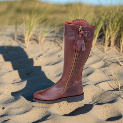 Spanischer Reitstiefel Caza mit Außenreißverschluss und Bommel am Zipper, Seitansicht, dargestellt am Strand