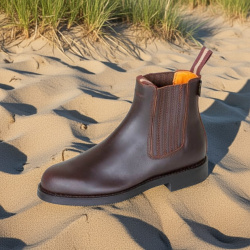 Spanische Reitstiefelette Cañada aus robustem Leder, mit verdecktem Gummizug, schräge Seitansicht, dargestellt in Sand