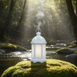 Hochwertiger Ultraschall-Diffusor "Lantern" von Young Living weiß, Laterne aus Metall mit Glas, dargestellt in der Natur